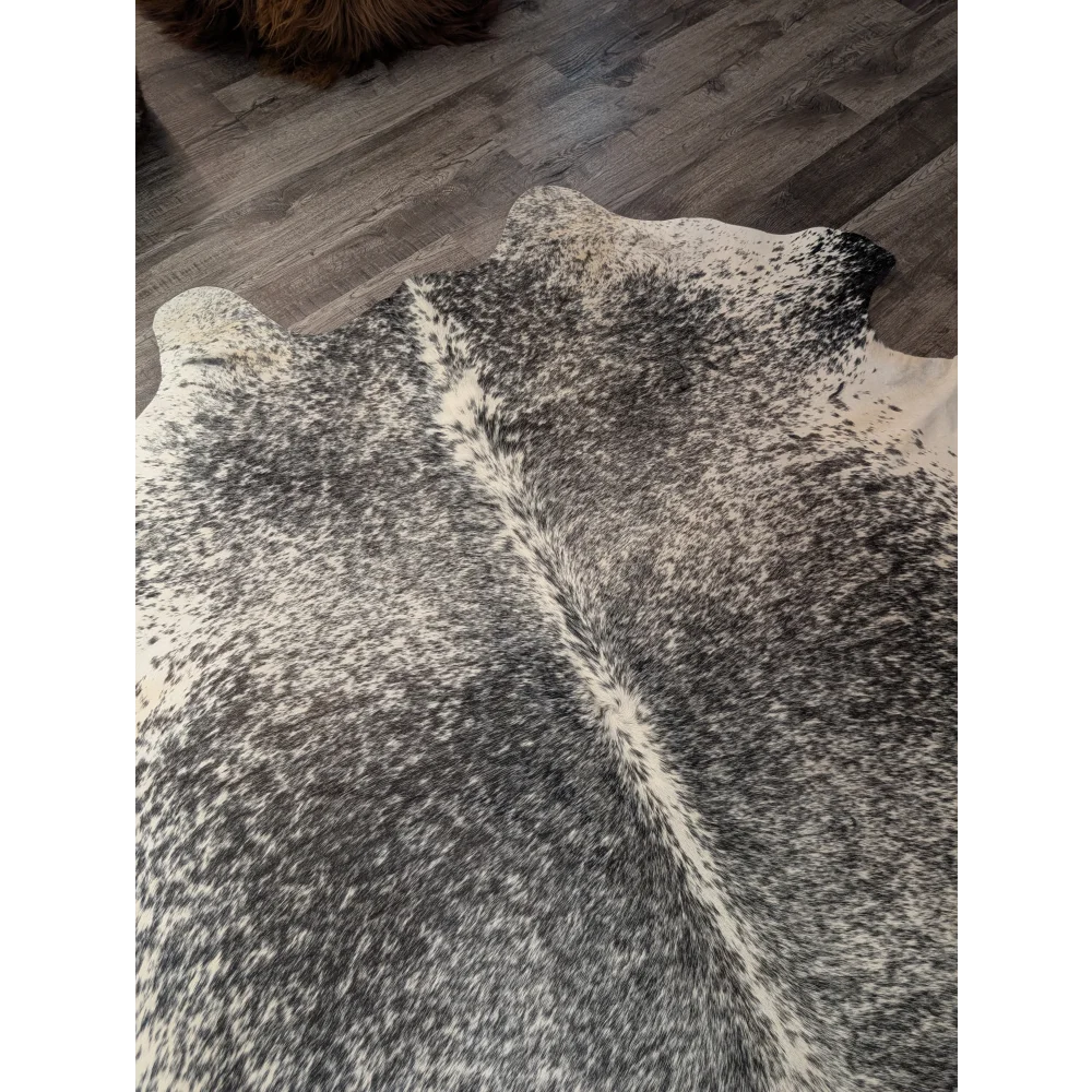 Large black and white angus oliver cowhide rug with natural textured surface perfect as a stylish floor accent