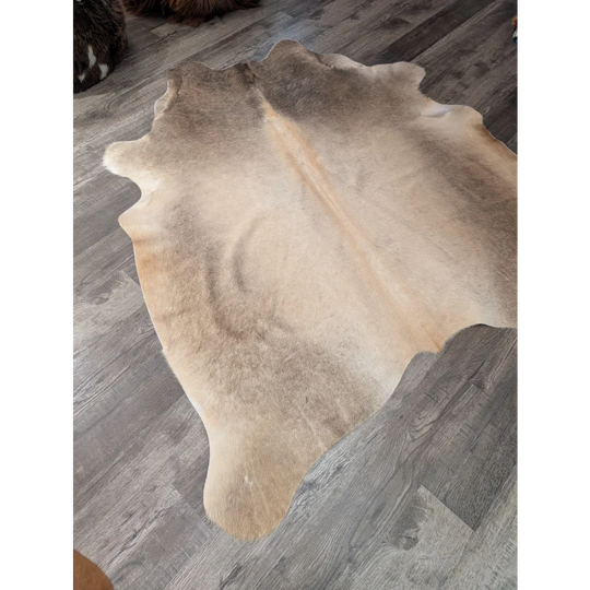 Large tan and beige natural cowhide rug by angus oliver with soft textured surface perfect for cozy spaces