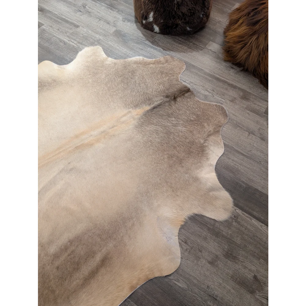 Large cowhide rug angus oliver with natural beige and brown tones and soft textured surface measuring 71 x 62 inches