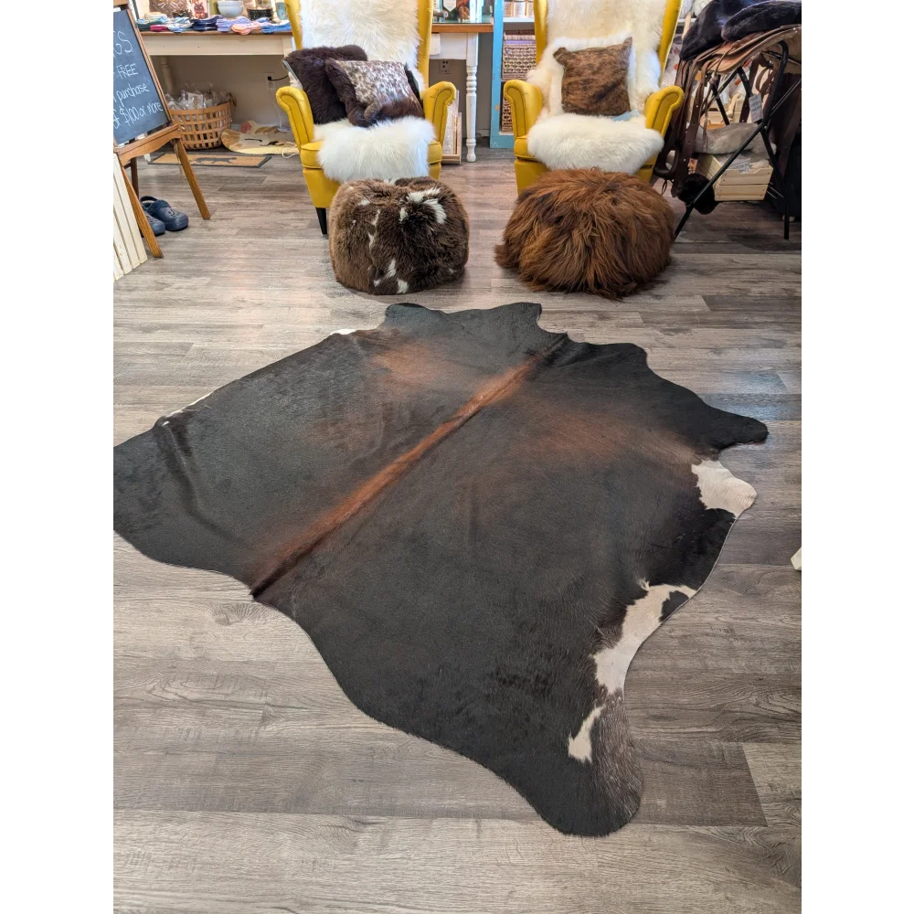 Large cowhide rug angus oliver with natural black and white cowhide and a brown stripe down the center
