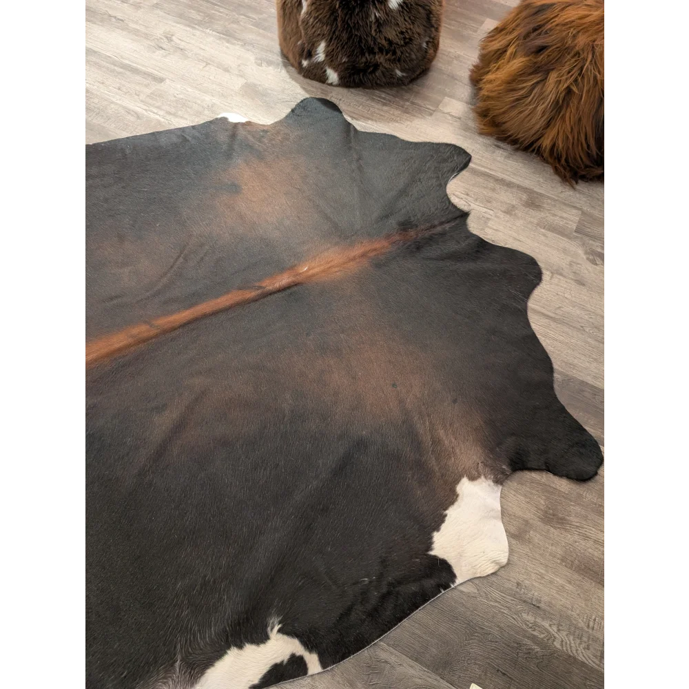 T27 large cowhide rug with natural black and white pattern and a bold brown stripe by angus oliver