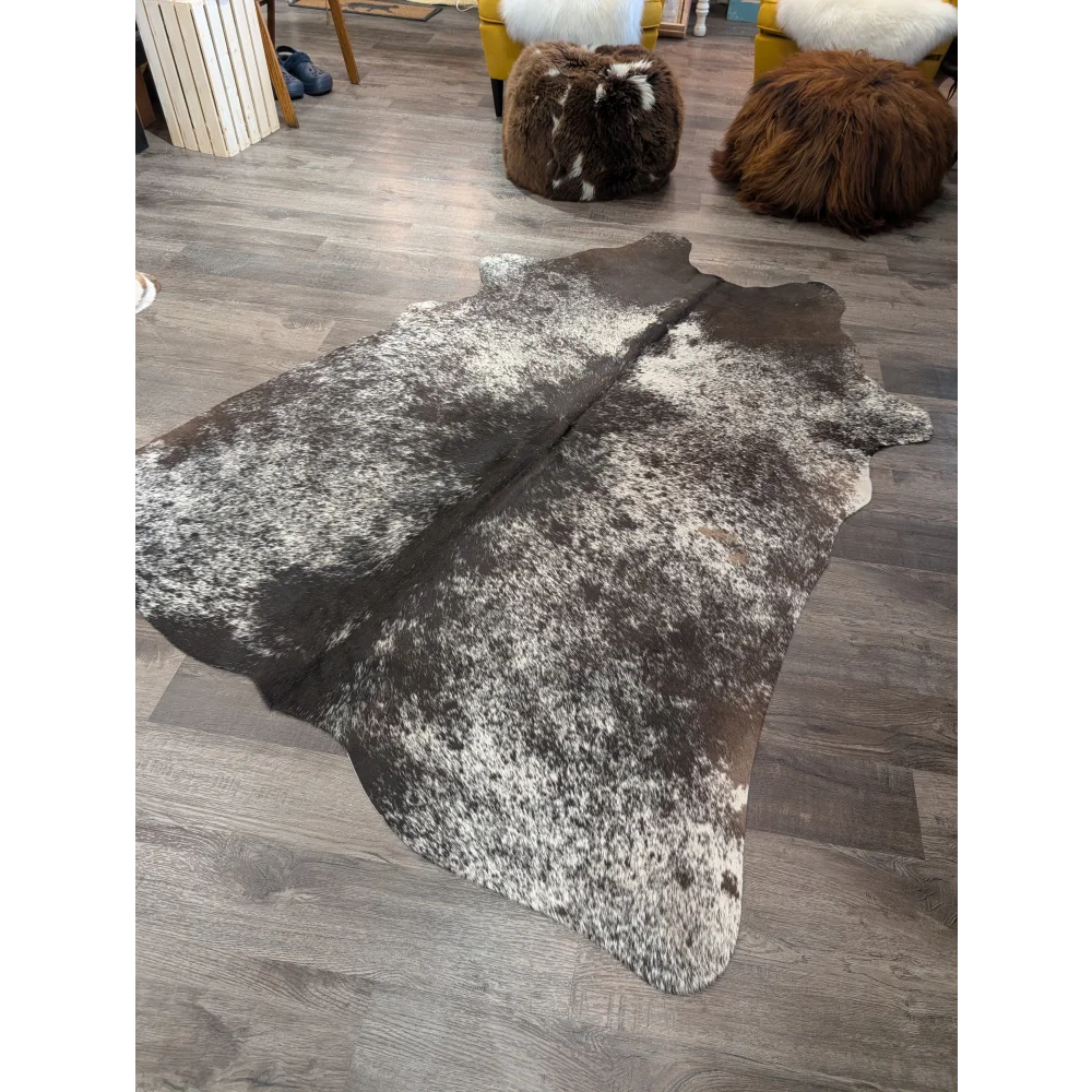 T28 76 x 62 large cowhide rug with a natural irregular shape and mottled dark brown and white pattern by angus oliver