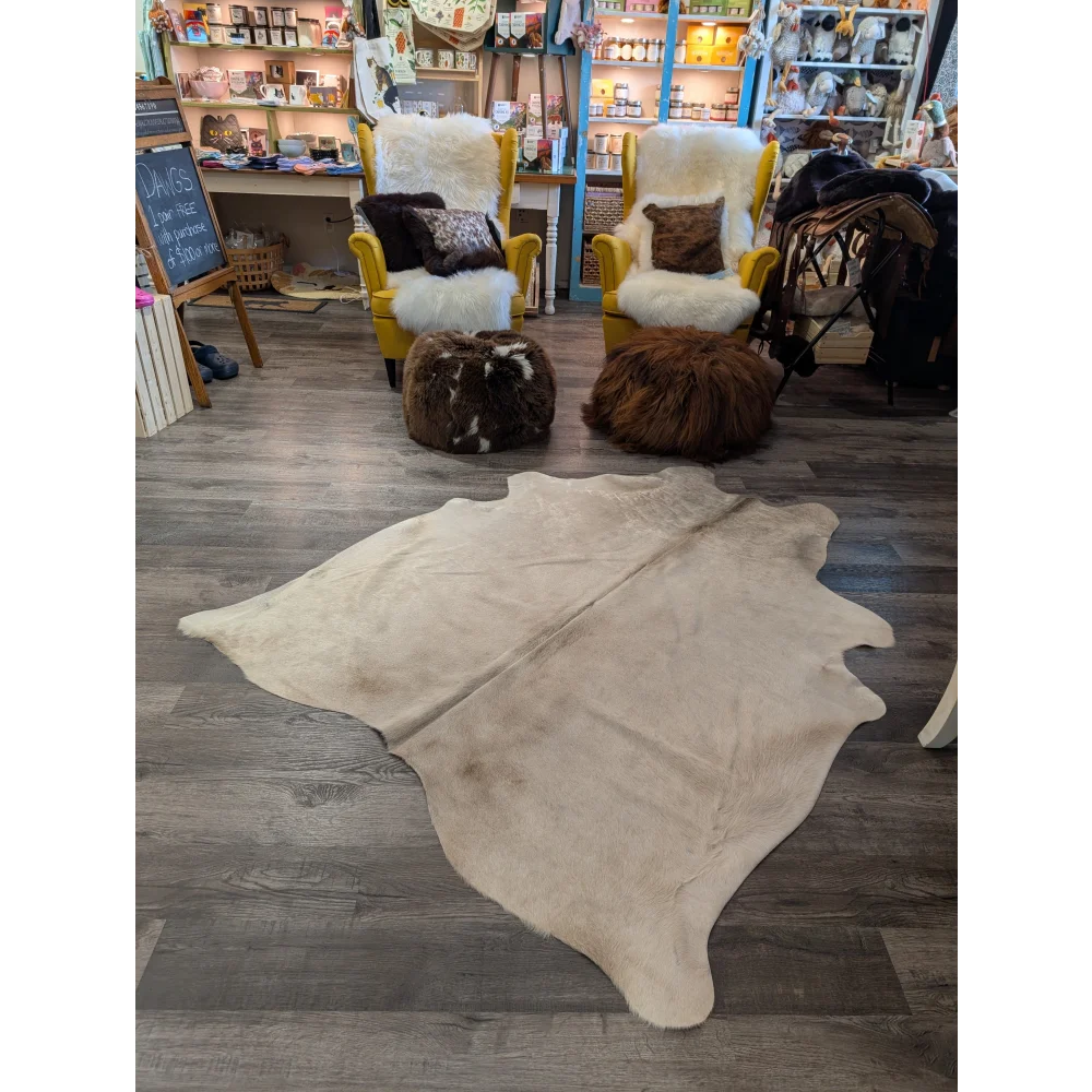 Cream-colored large cowhide rug with natural fur texture and irregular edges from angus oliver t#29