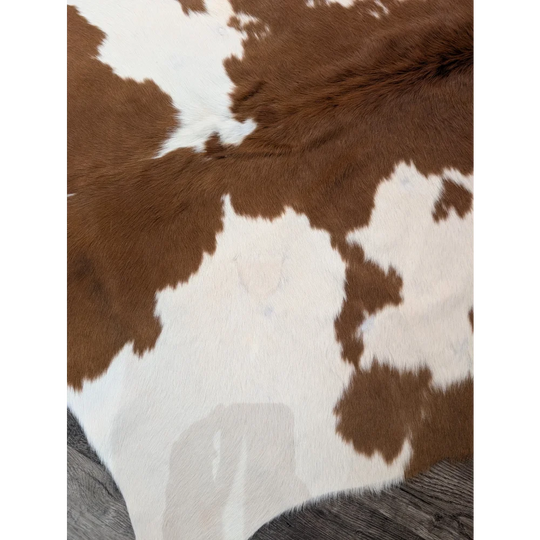 Large brown and white angus oliver cowhide rug with natural fluffy texture perfect as a stylish floor decor