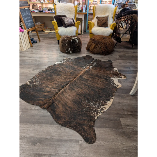 Large brown and white cowhide rug with natural irregular patterns perfect for angus oliver style spaces