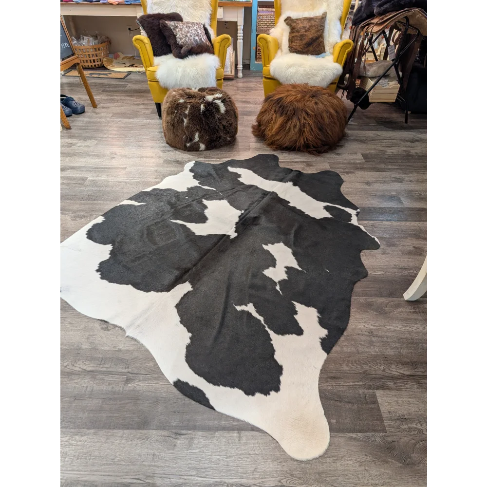 Large black and white cowhide rug with natural irregular patches perfect for angus oliver decor measuring 73.5 by 64 inches