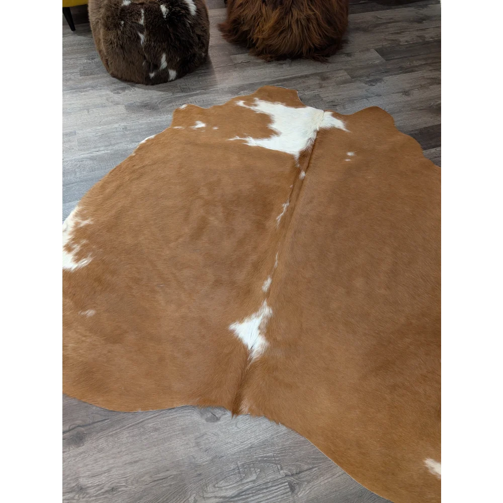 Large brown and white cowhide rug with natural fur texture perfect for cozy home decor by angus oliver