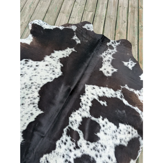 Large cowhide rug 70 x 62.5 inches with black and white natural irregular patches and unique characteristics