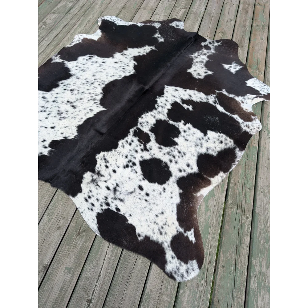 T4 70 x 62.5 large cowhide rug with unique characteristics and natural irregular dark brown patches on white fur