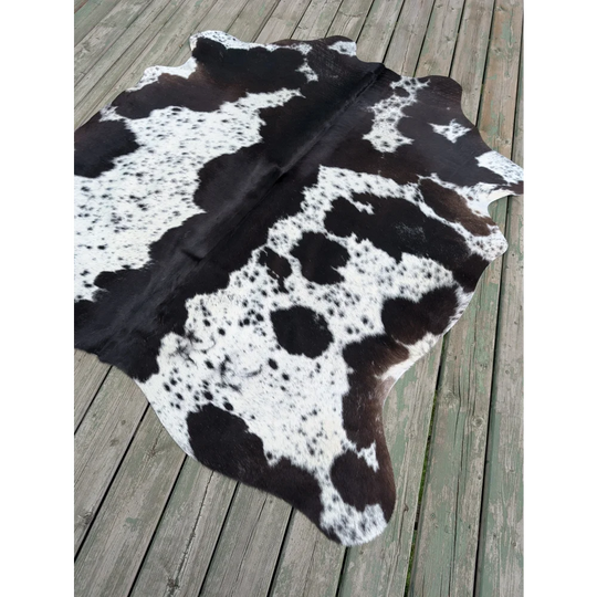 T4 70 x 62.5 large cowhide rug with unique characteristics and natural irregular dark brown patches on white fur