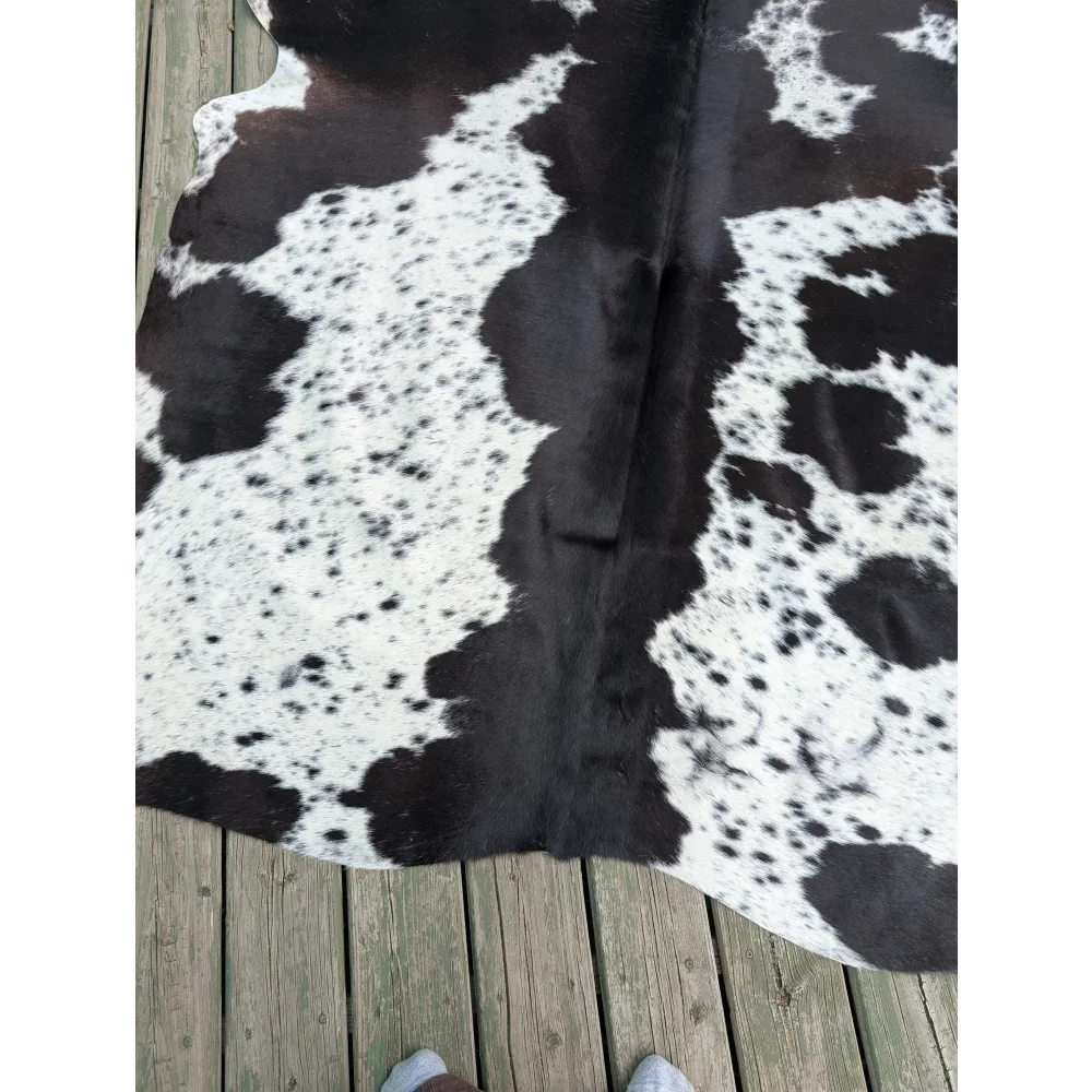 Large cowhide rug with black and white natural irregular patches showcasing unique characteristics and style