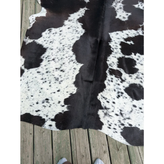 Large cowhide rug with black and white natural irregular patches showcasing unique characteristics and style