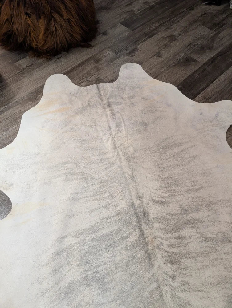 T#41 76 x 70 large cowhide rug by angus oliver with a natural white and gray soft textured surface