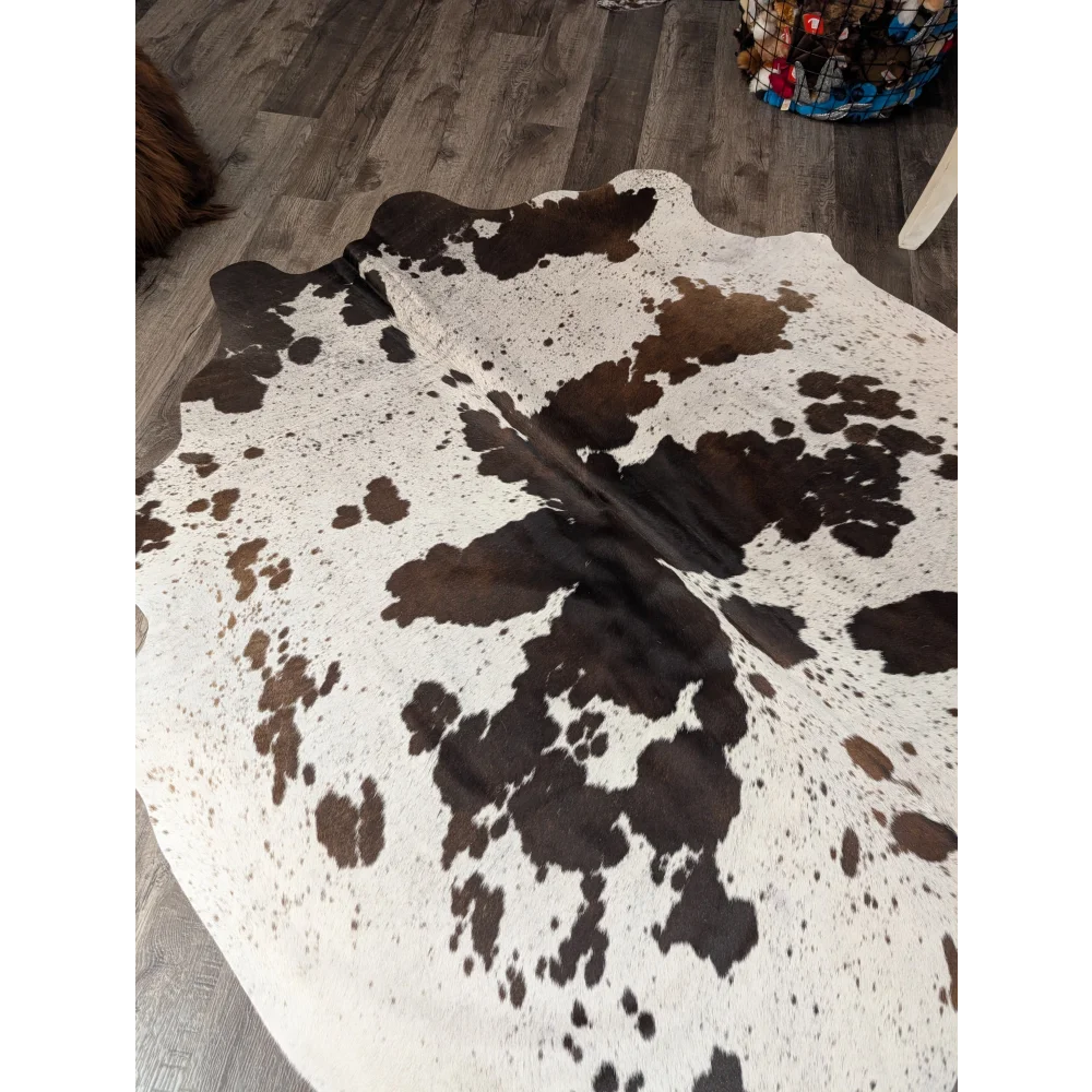 Large cowhide rug angus oliver with a natural white and brown pattern and irregular dark patches 69 by 66 inches