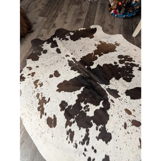 Large cowhide rug angus oliver with a natural white and brown pattern and irregular dark patches 69 by 66 inches