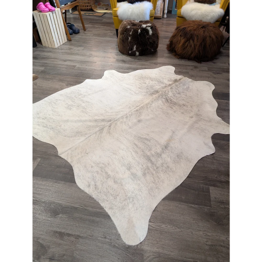 Large cowhide rug by angus oliver featuring a natural white and gray soft textured cowhide surface