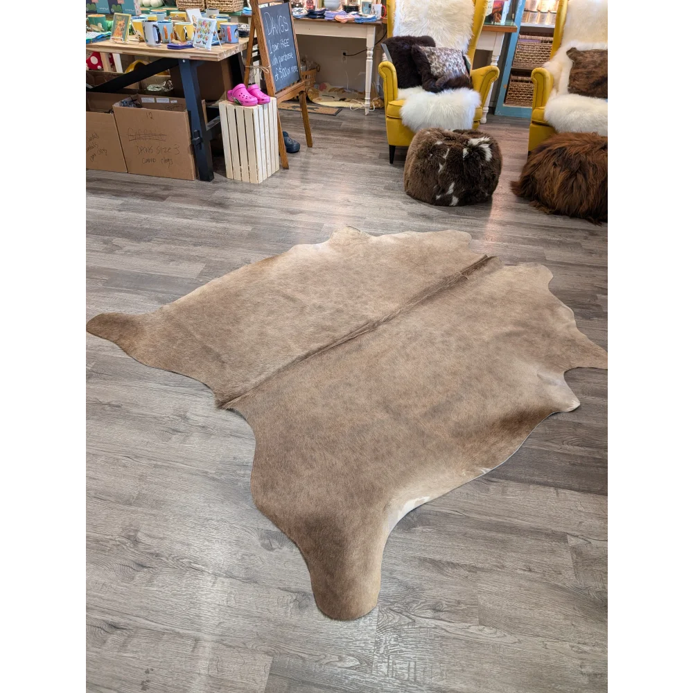 Natural tan large cowhide rug with soft textured surface and irregular edges from angus oliver t45 77 x 64