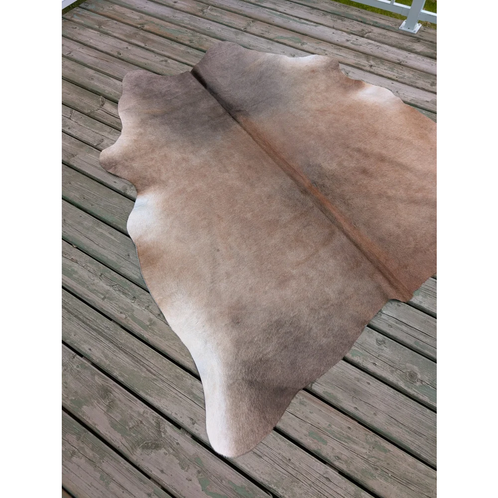 Natural tan and beige large cowhide rug with soft textured surface showcasing unique characteristics