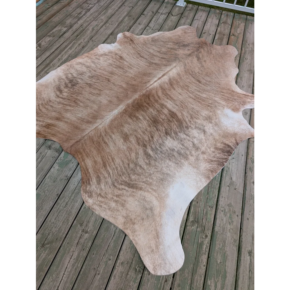 T6 80 x 70 large cowhide rug with unique tan and white patterns and a soft textured surface on a wooden deck
