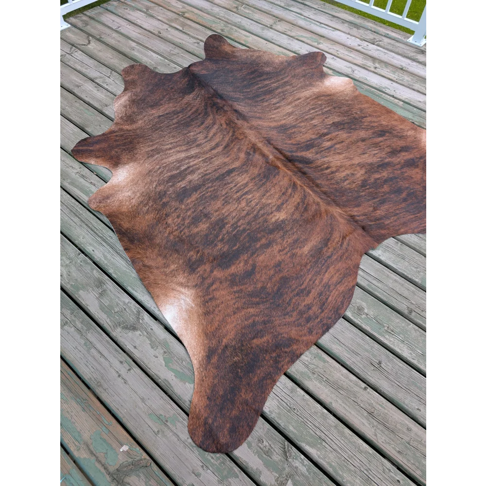 Large cowhide rug with brown and black natural fur texture showcasing unique characteristics and size 76 by 76 inches