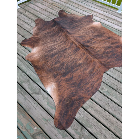 Large cowhide rug with brown and black natural fur texture showcasing unique characteristics and size 76 by 76 inches
