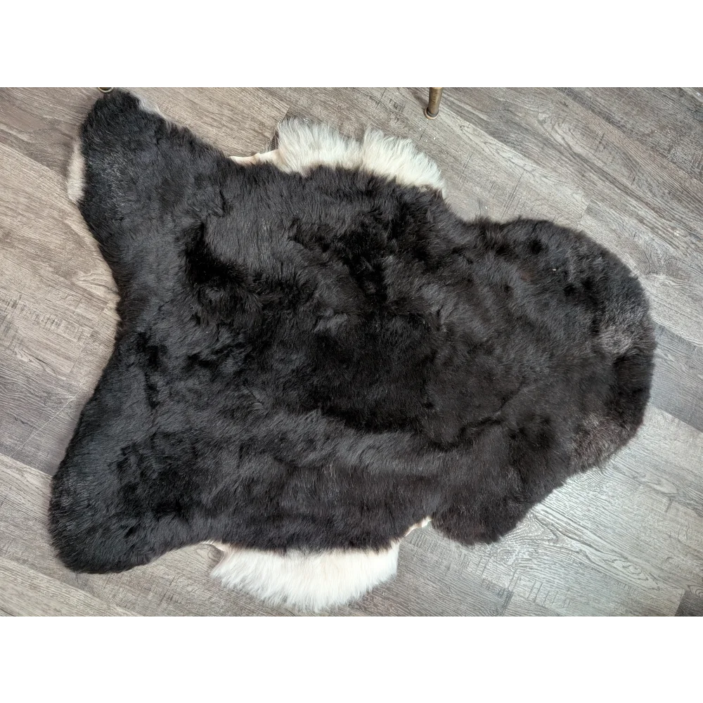 Large black and white fluffy icelandic sheepskin rug with short wool texture perfect for cozy decor