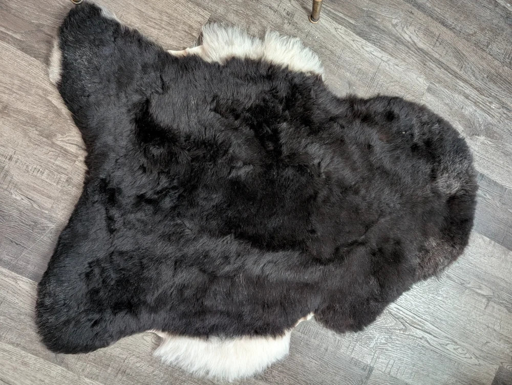 Large black and white fluffy icelandic sheepskin rug with short wool texture perfect for cozy decor