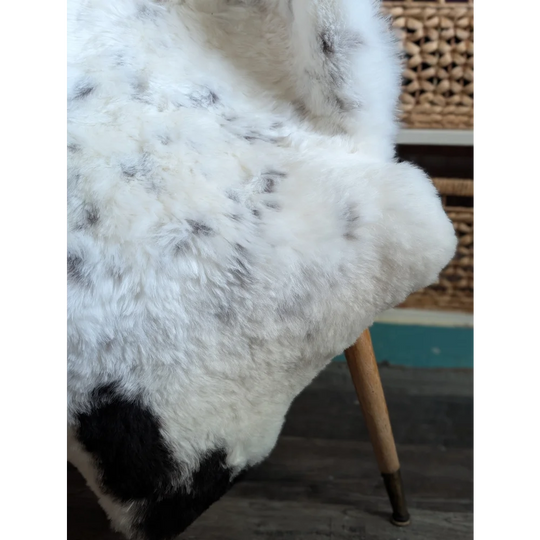 White and black spotted icelandic sheepskin rug with soft fluffy faux fur perfect as a spotted icelandic sheepskin throw
