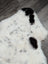 A large spotted icelandic sheepskin rug in white and black with soft fluffy faux fur texture perfect for cozy spaces