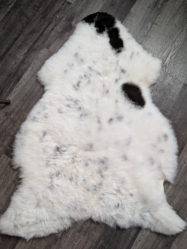 Large spotted icelandic sheepskin rug in white with black and gray speckles made from short wool