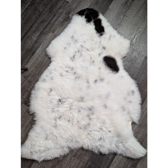 Large spotted icelandic sheepskin rug in white with black and gray speckles made from short wool