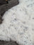 Large spotted icelandic sheepskin rug with soft white fluffy texture and subtle gray speckles made of short wool