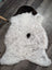 A plush white medium spotted icelandic sheepskin rug with soft wool and two distinct black patches near the top