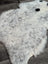 A large spotted icelandic sheepskin rug with soft white and gray speckled fluffy wool for cozy decor