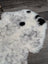 A large plush spotted icelandic sheepskin rug in white and black with soft fluffy texture for cozy decor