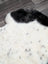 A plush white and black medium spotted icelandic sheepskin rug with soft fluffy texture 45 by 30 inches