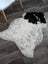 A large irregular icelandic sheepskin rug with soft white base and bold black spots medium spotted icelandic wool