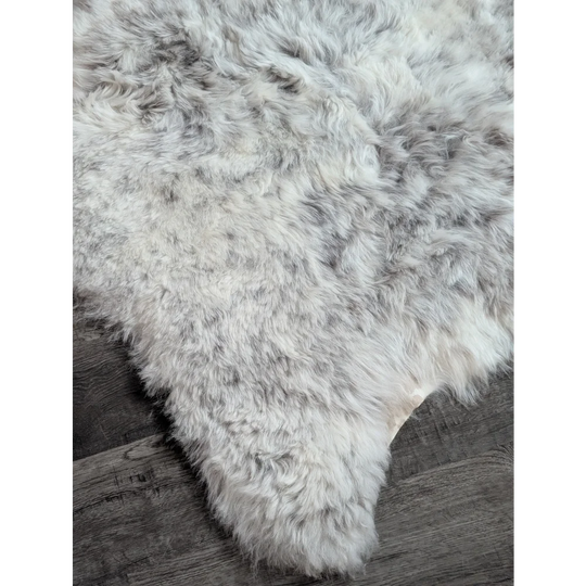 A large 43 x 33 gray plush spotted icelandic sheepskin rug with soft medium wool and natural irregular edges