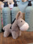 A soft plush donkey toy called the donkey with a tan body white muzzle and black ears and tail accents