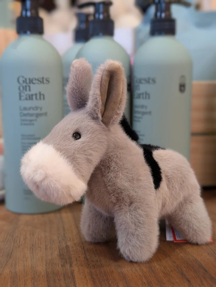 A soft plush gray donkey toy with white muzzle and black saddle called the donkey perfect for kids and collectors