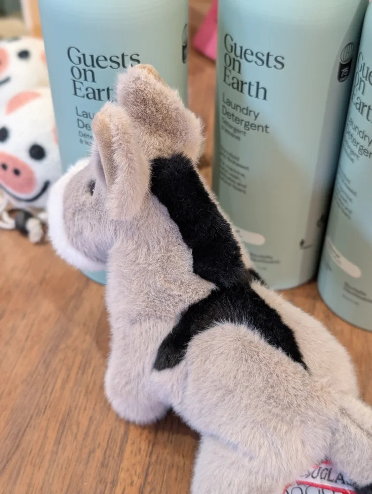 A plush gray and black cow toy called the donkey with a soft fuzzy texture perfect for cuddling