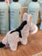 A soft plush donkey toy called the donkey with gray and black fur and white accents on its muzzle and ears