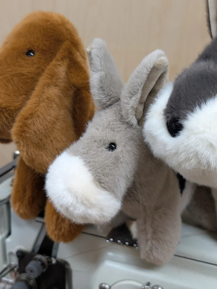 Gray plush donkey with white muzzle and black button eyes named the donkey perfect for cuddling or gifting