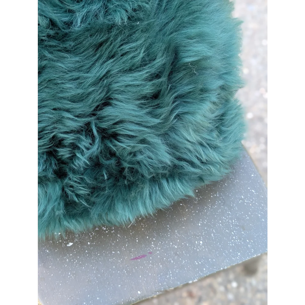 The green cushion is a plush dyed green faux fur pillow with soft shaggy texture inspired by angus oliver style