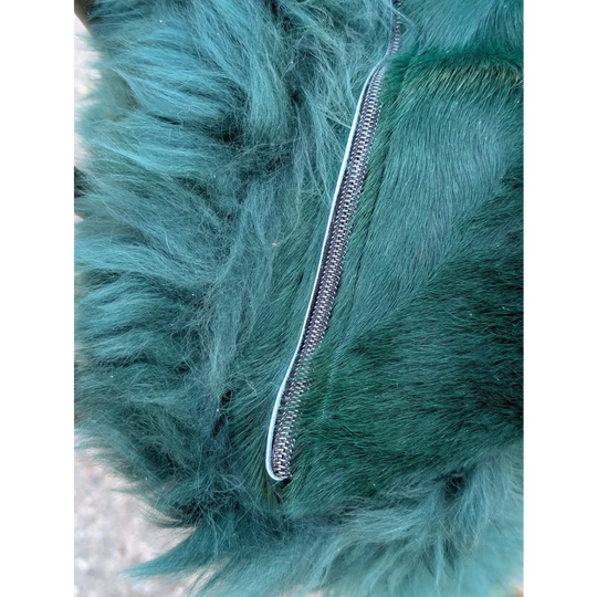 The green cushion features a dyed green plush faux fur with a sleek metallic zipper for angus oliver style
