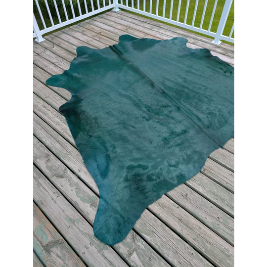 The green cushion features a dyed green angus oliver green cowhide rug with natural edges and subtle texture