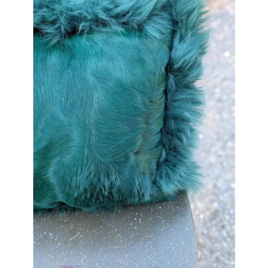 The green cushion is a plush teal green faux fur bag with a soft textured surface and dyed green edges by angus oliver