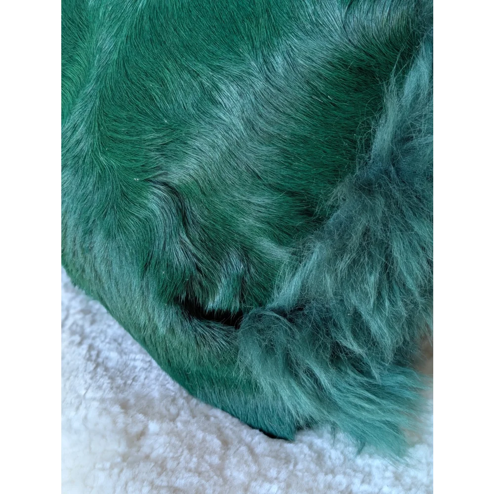 The green cushion is a plush emerald dyed green faux fur blanket with a soft dense texture by angus oliver