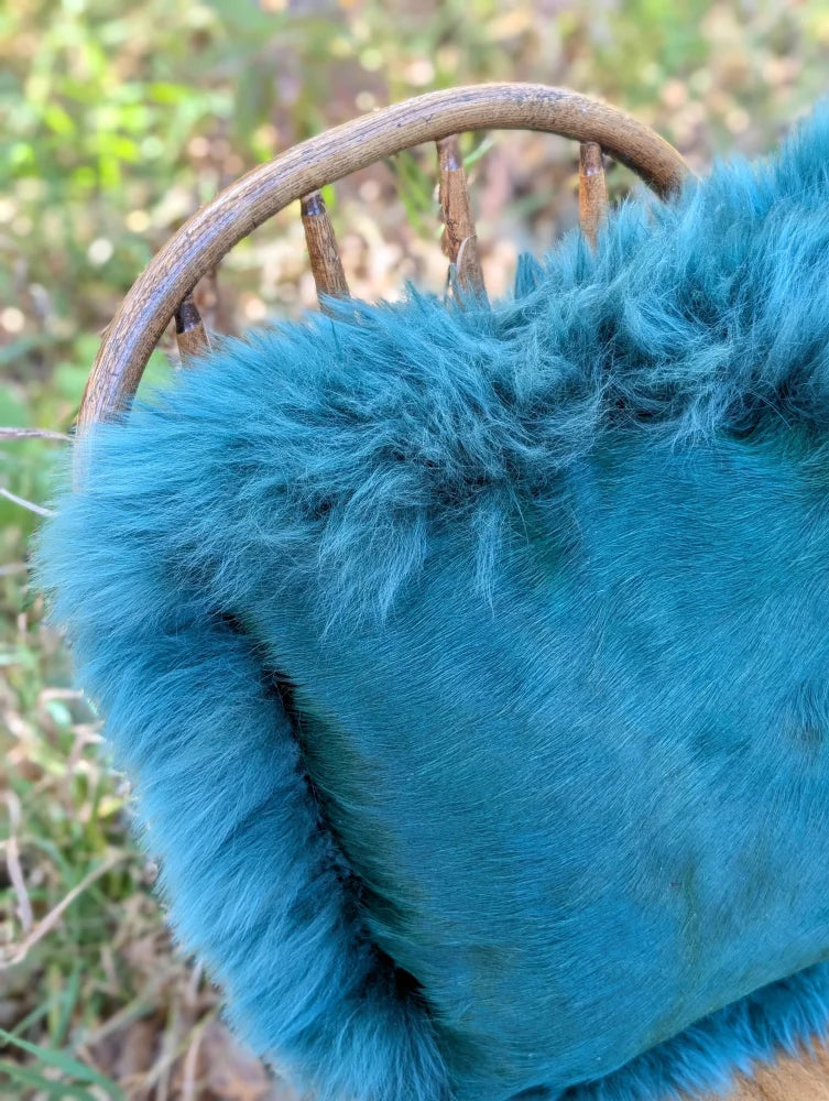 A plush teal woolly green faux fur handbag with soft fluffy texture and visible stitching from the green sheepskin sewing studio