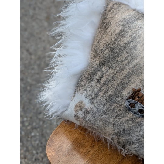 The moo cushion 2 is a plush pillow with a mottled gray and white hide surface edged in soft white long wool faux fur